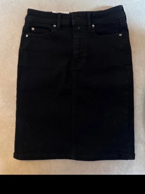 Svart jeanskjol med fickor - En helt oanvänd svart jeanskjol från Cubus, rak passform och något längre 