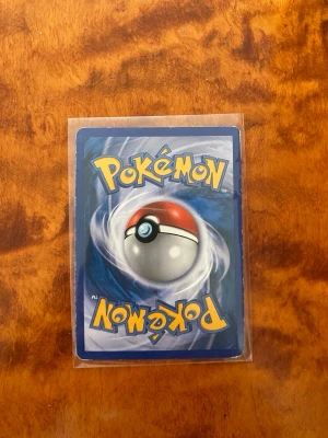 MintPikachu #7 Pokémon Rumble Promo (English) - Near - Säljer ett samlarkort från Pokémon Rumble-serien med Pikachu på framsidan. Kortet är guldfärgat med färgglad illustration och text, samt detaljer om attacken Volt Tackle. Kortet är tillverkat i papper och plast och ligger i ett skyddande plastfodral.
