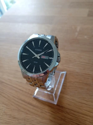 Citizen Dress 41mm Herrklocka - Säljer en snygg stilren herrklocka från eftertraktade japanska Citizen i nära nyskick enligt bilder. Enstaka tunna repor som ej stör. Tid, dag och datum går att ställa, originalarmband i rostfritt stål, smidigt viklås med knappar, dag och datumvisare, mineralglas, japanskt urverk, självlysande, vattentät, osv. Behöver nog bara nytt batteri. Modell: BF2011-51EE. Se specifikationer längst ned.  Nypris: 1150 SEK Mitt pris: 698 SEK