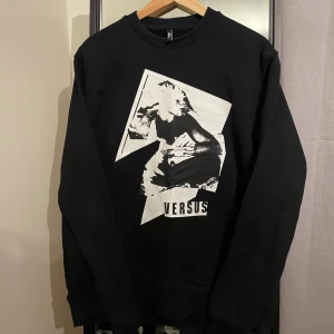 Unik långärmad tröja från Versus - Säljer en svart långärmad tröja från ”Gianni Versace (Versus) med en cool vit grafisk design på framsidan. Den är i nyskick, Storlek M. Nypris 5000kr. Perfekt för en avslappnad stil och passar bra till både jeans och sneakers. Tröjan är i bra skick och redo för nya äventyr!