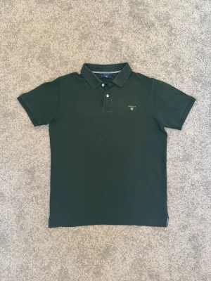 Mörkgrön piké t-shirt från Gant - Snygg mörkgrön pikétröja från Gant, perfekt för sommarn och hösten | Skick: 8/10 inga defekter | Storlek: EU S | tvättas och fräschas upp innan frakt | priset kan diskuteras vid snabb affär🤝