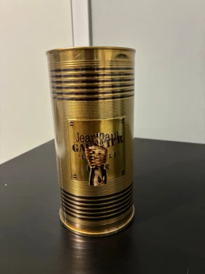 Jean Paul Gaultier Le Male EdT 125ml - Jean Paul Gaultier Le Male Eau de Toilette i en ikonisk guldfärgad metallburk med randigt mönster och reliefdetaljer. Flaskan är känd för sin unika design och doften är en klassiker inom herrparfym. Perfekt för dig som gillar exklusiva och tidlösa dofter.