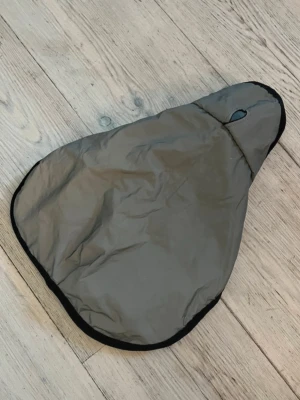Grå vattenavvisande hundjacka - Säljer en grå hundjacka i reflex med svart kant och mjukt innerfoder. Jackan har hål för sele eller koppel och är lätt att ta på och av. Vattenavvisande och reflex på utsidan. Passar bra för promenader när det är kallt ute.
