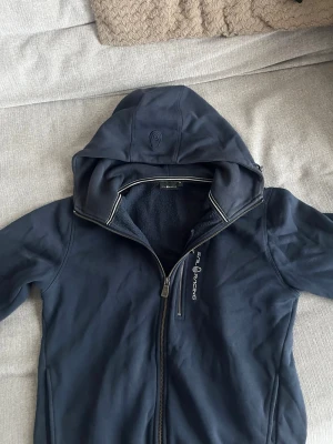 Sail Racing zip hoodie mörkblå  - Säljer denna snygga sail racing zip hoodie i färgen mörkblå som har använts ett fåtal gånger. Passar till alla tillfällen och är riktigt skön. Kan gå ner i pris i en snabb och smidig affär! Köparen står för frakten😁