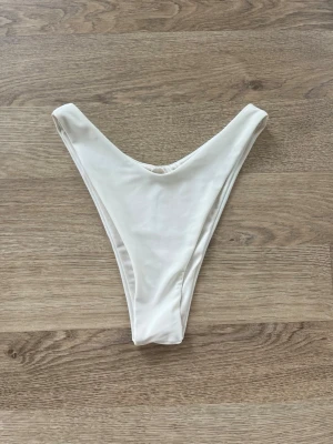 Vit bikiniunderdel - Vit bikiniunderdel med V-formad skärning. Perfekta för stranden eller poolen, med enkel och stilren design. Från Bik Bok i storlek XS. Använda en gång. Pris går att diskutera!