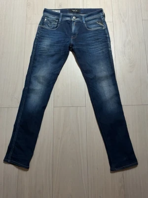Blåa Replay jeans anbass - Säljer mina replay jeans då de inte används. Dem är i bra skick och finns knappt tecken på att de e använda. Jeansen är in suddad på in sidan som man kan se i sista bilden för att det ska sitta lite mer slim fit. Pris går att diskutera vid snabb affär! 