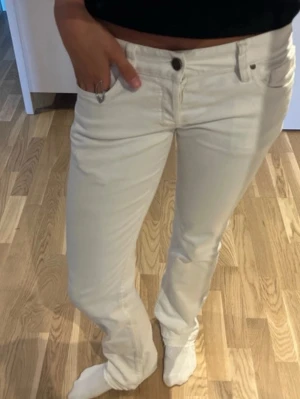 Vita utsvängda jeans med låg midja - Säljer ett par vita utsvängda jeans med låg midja. Klassisk femficksmodell med knapp & dragkedja framtill. Jeansen har en enkel & stilren look som passar till det mesta ❤️❤️❤️innebenslängd: 82 cm & midjemått rakt över: 37 cm