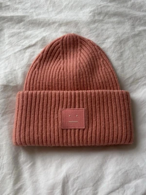 Acne Mössa  - Säljer min rosa Acne Mössa i ull, klassisk modell. Storleken är 56cm. Använd ett fåtal gånger. Orginalpris cirka 1700kr. 