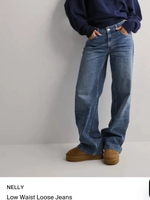  low waist loose jeans - Säljer ett par blå low waist loose jeans från NELLY, köps på hemsidan för 699, lite slitningar bak se bild