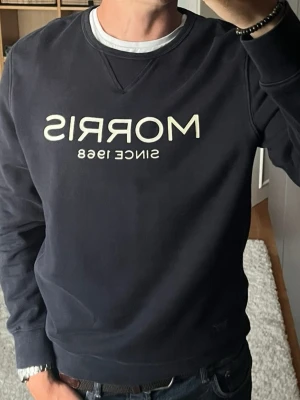 Morris sweatshirt i marinblå - stl M - Morris sweatshirt i marinblå, storlek M. Mjukt och lite tjockare tyg. Ganska rak passform, funkar bra nu till hösten. Personen på bilden är 189cm, väger 78kg.   Använd men i mycket fint skick, inga hål eller fläckar.  Rök- och djurfritt hem. Skriv gärna om du vill ha fler bilder eller undrar något!