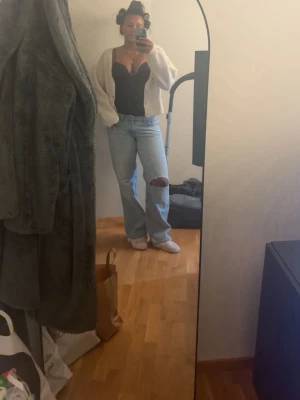 Zara jeans - Säljer ett par ljusblå jeans med rak passform och ett stort hål på ena knät. Jeansen har klassisk femficksdesign och normal midja. Perfekta för en avslappnad och trendig look.