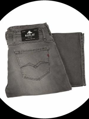 Gråa jeans från Replay - Snygga grå jeans från Replay med klassisk femficksdesign och diskret logga på bakfickan. Jeansen har raka ben och är tillverkade i ett mjukt denimtyg som ger en skön passform. Perfekta för dig som gillar en stilren och avslappnad look.