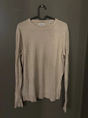 Stickad tröja - Tja!! Jag säljer en stilren beige stickad tröja från Jack & Jones. Tröjan har rund halsringning, långa ärmar och ribbade muddar vid ärmslut och nederkant. Perfekt för lager på lager och enkel att matcha med olika outfits. Tröjan är i fint skick och bara att fråga vid funderingar:))