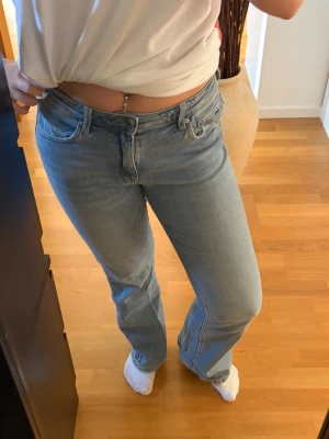 Ljusblå bootcut jeans - Säljer ett par ljusblå bootcut jeans med klassisk femficksmodell och mid waist. Jeansen har raka ben med lätt utsvängning nedtill och är gjorda i ett mjukt denimtyg. Perfekta för en avslappnad och trendig look. Skriv pm vid funderingar!