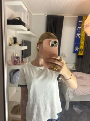 Vit t-shirt med svart detalj - Säljer en fin t-shirt, har ett litet hål som knappt märks och några fläckar på baksidan som ja skulle tro går bort i tvätten💕