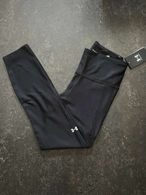 Under Armour Leggings (Medium) - Svarta ankle leggings från Under Armour med hög midja och kompressionseffekt.  Stl M                   Helt ny Nypris (599)