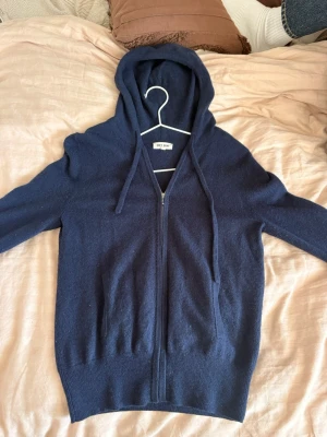 Soft goat hoodie - Mysig soft goat mörkblå hoodie med dragkedja framtill och två fickor i väldigt bra skick. Tillverkad i kashmire, klassisk huva med dragsko och ribbade muddar vid ärmslut och nederkant. Perfekt för en avslappnad och stilren look.