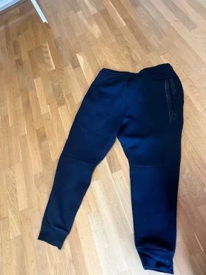 Svarta mjukisbyxor från Polo Ralph Lauren - Snygga svarta mjukisbyxor från Polo Ralph Lauren med dragsko i midjan och klassisk logga broderad på benet. Sköna muddar vid bensluten och mjukt material som passar perfekt för chill eller träning.