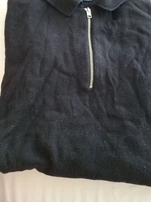 Svart halvzip tröja Jack & Jones - Snygg svart stickad tröja från Jack & Jones med halvzip och krage. Perfekt till jeans eller chinos. Tröjan har en stilren look och är tillverkad i mjukt material som känns skönt mot huden.
