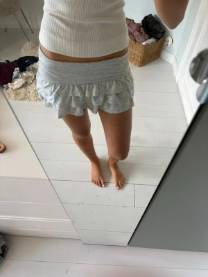 Grå mini volangkjol - Supersöt ljusgrå minikjol med inbyggda shorts. Tillverkad i mjukt bomullstyg som är riktigt bekvämt. Storlek S men väldigt liten i storlek. 💕