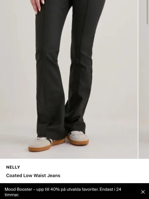 Svarta coated low waist jeans Nelly - Snygga svarta coated jeans från Nelly med låg midja och raka ben som har en lätt utsvängd passform. Jeansen har framfickor, bälteshällor och en glansig finish som ger en trendig look. Perfekta för dig som vill ha en edgy stil. Kostar 699kr på nelly