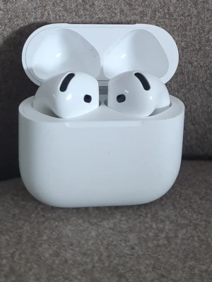 Airpods 4 - Snygga trådlösa in-ear hörlurar i vit plast med laddningsetui. Smidig design som passar perfekt i fickan och ger dig frihet utan sladdar. Perfekta för musik, poddar och samtal på språng.