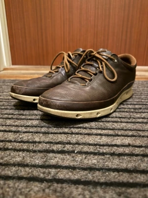 Ecco Skor - Fina mörkbruna skor från Ecco i läder. Skorna är i ganska bra skick som ni ser på bilderna. På framsidan av varsin sko finns det slitage och även på baksidan av högra skon. 