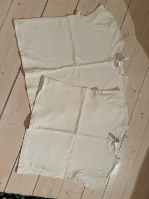 Vita basic t-shirts från H&M - Två klassiska vita basic t-shirts från H&M med rund hals och korta ärmar. Perfekta till alla outfits och tillverkade i mjuk bomull för skön känsla. Enkel och clean design som alltid funkar. Säljs tsm 