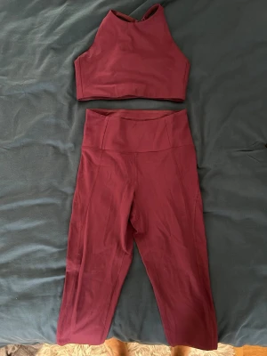 Mörklila träningsset  - Säljer ett mörklila (lila framför vinrött som bilden utger) träningsset med crop top och matchande höga tights. Toppen har brottarrygg och bred resår under bysten. Tightsen är höga i midjan och har en smickrande passform. Materialet är stretchigt och mjukt, perfekt för träning eller till vardags. Sparsamt använt. Storlek S. 70 kr för hela setet.