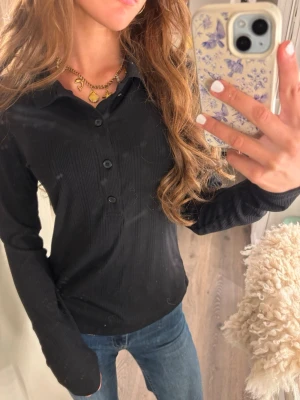Svart ribbad långärmad tröja - Supersöt Svart ribbad tröja med lång ärm, klassisk krage och knappar framtill. Väldigt bra skick aldrig använd💕