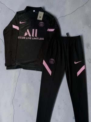 Svart PSG träningsset med rosa detaljer - 🔥⚽ PSG Träningsset ⚽🔥  🖤💗svart och rosa PSG-set 👕 Långärmad träningströja med dragkedja 👖 Matchande träningsbyxor 🧸 Mjukt & bekvämt material 💪 Perfekt för träning, fotboll och vardag ✨ Snygg PSG-design med detaljer som sticker ut 😎 Sportig & clean fit 🏃‍♂️ Skönt set att bära både på planen och till vardags  📏 Storlek: () 💯 Skick: Nytt 💸 Pris: (lägg till pris)  📩 DM vid intresse eller frågor 🚨 Först till kvarn gäller! 🔥  #PSG #ParisSaintGermain #Fotboll #Träningsset #Fotbollskläder 