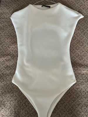 Vit body med öppen rygg - Säljer en stilren vit body i stretchigt material. Aldrig använd. 