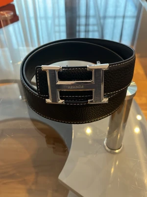Svart skärp med silverfärgat H-spänne - Riktigt bra kvalité, kommer med original förpackning. Pris går att diskuteras.