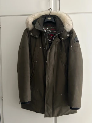 Moose Knuckles Parka - Fin Moose Knuckles parka jacka med äkta päls. Använd under två vintrar så fortfarande i väldigt bra skick. Storlek M.