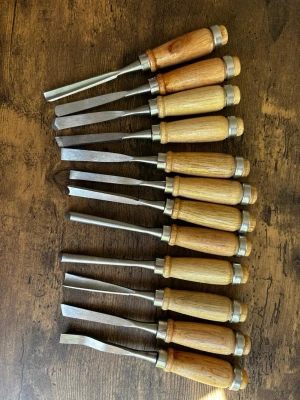 Set med 12 st stämjärn i trä och metall - Säljer ett set med 12 stämjärn med handtag i ljust trä och blad i metall. Perfekt för träslöjd, snickeri eller hobbyprojekt. Handtagen har metallringar för extra hållbarhet och greppvänlig form. Olika bredder och former på bladen för varierande användning.