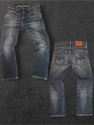 Sinnessjuka Levis 551 i straight fit(sjuk wash) - Säljer ett par blå Levi's jeans med snyggt slitna detaljer och whiskers på benen. Klassisk femficksmodell med raka ben och läderpatch bak i midjan. Jeansen har en cool tvättad look och är tillverkade i denim.