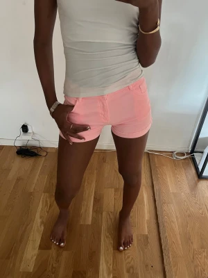 Ljusrosa shorts med fickor!💕💗 - Säljer ett par ljusrosa shorts med normal passform och klassisk femficksdesign. Shortsen har knapp och dragkedja framtill samt bälteshällor. Perfekta för varma dagar och enkla att matcha med olika toppar.💗💗✨