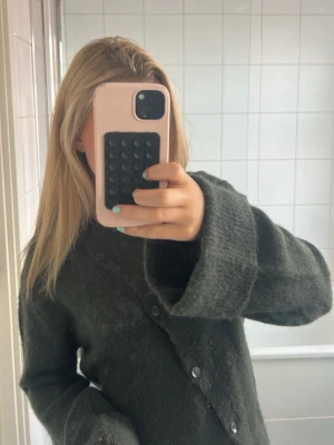 Mörkgrå oversized kofta - Mysig mörkgrå kofta med oversized passform och stora knappar framtill. Koftan har långa ärmar.