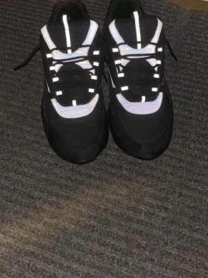 B22 svarta med box  - Säljer ett par svarta chunky sneakers med vita detaljer och tjock sula. Skorna har en sportig design med mesh och syntetmaterial, samt svarta och vita snören. Perfekta för dig som gillar streetwear och vill sticka ut.