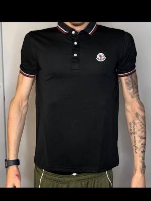 Svart Moncler pikétröja - Säljer denna fina Moncler Piké i bra skick.   Storlek: [M men sitter som S] Skick: [mycket bra] Färg: [Svart]  Passform: [Slim] Skickas snabbt och välpackat!