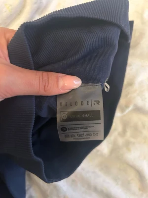 Mörkblå leggings från Relode XS - Säljer ett par mörkblå leggings från Relode i storlek XS. De har hög midja och är tillverkade i ett stretchigt material som sitter tight och bekvämt. Perfekta för träning eller chill dagar. Snygg och enkel design utan synliga loggor framtill.