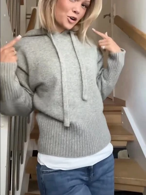 Zara ljus grå hoodie  - Mysig ljusgrå stickad hoodie med huva och dragsnören. Tröjan har bred ribbstickning vid ärmslut och nederkant, samt en avslappnad passform. Perfekt för en chill och stilren look.