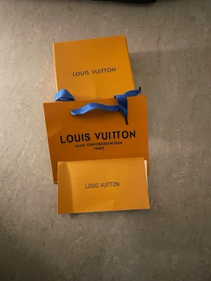 Svart Louis Vuitton bälte med monogram - Säljer ett svart bälte från Louis Vuitton med det klassiska monogrammönstret i grått. Bältet har en stilren design och levereras med originalförpackning och påse. Perfekt accessoar för att lyfta din outfit.