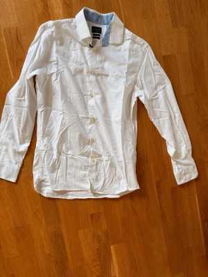 Vit skjorta  - Säljer en vit skjorta från Selected Homme i storlek M slim fit då jag vuxit ur den. 