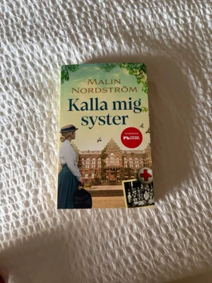 Kalla mig syster av Malin Nordström - Fängslande historisk roman av Malin Nordström, första delen i serien Drömmarnas sekel. Boken har ett omslag i ljusa färger med motiv av en kvinna i tidstypiska kläder framför ett klassiskt hus. Perfekt för dig som gillar berättelser om mod, kärlek och systerskap.