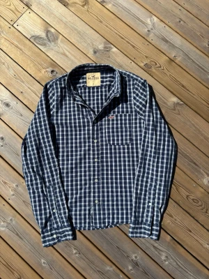 Hollister skjorta ~ Vintage  - Säljer denna Hollister skjorta i mycket bra skick och som även är Vintage därmed eftertraktad. Storlek L. Passar perfekt för dig som är mellan 180-185! Hör av er vid frågor eller minsta fundering 🙌  Längd: 69 cm  Bred: 52 cm  Ärm: 73 cm