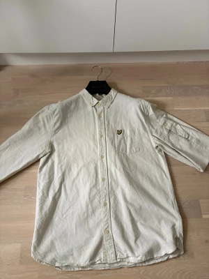 Ljus gul lyle&scott skjorta - Säljer min snygga lyle&scott skjorta i en ljus gul randig färg! I storlek L men kan passa storlek M. Tröjan är perfekt som en stilig skjorta eller en overshirt med t shirt under! 