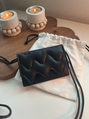 New Marimekko Lokki belt bag (black) - Unused Marimekko Lokki belt bag, black. Fits items such as cards well. Length: 11 cm, width: 0.5 cm, height: 8 cm. Discontinued model. 