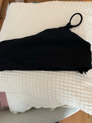 Svart bikiniöverdel från Nakd - Säljer en svart bikiniöverdel från Nakd i storlek M. Toppen har ett axelband. 25 kr!