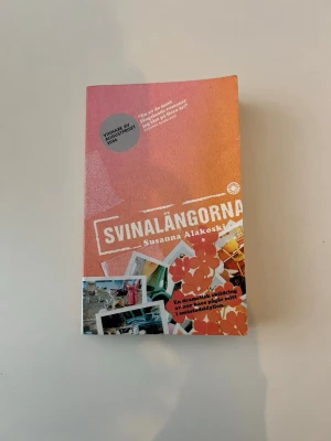 Svinalängorna av Susanna Alakoski - Romanen 'Svinalängorna' av Susanna Alakoski är en pocketbok med färgstark orange och rosa framsida. Boken skildrar en dramatisk uppväxt i ett svenskt miljonprogram under 70-talet och är känd för sitt starka sociala tema. Vinnare av Augustpriset 2006.